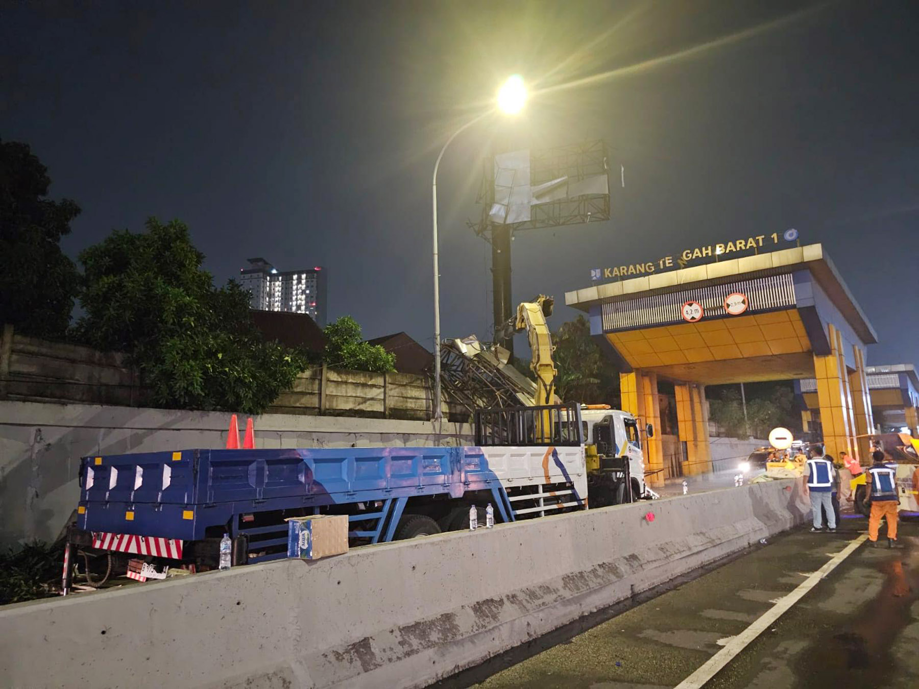 Petugas memperbaiki konstruksi iklan (billboard) roboh dan menutup akses keluar bekas Gerbang Tol (GT) Karang Tengah Barat 1.