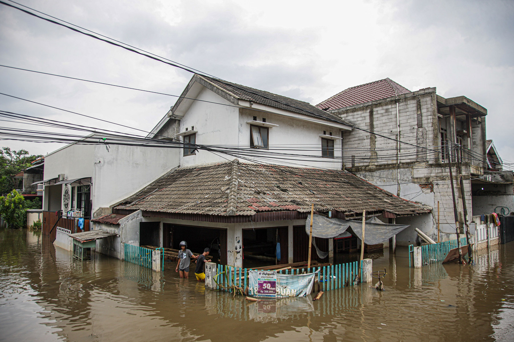 Sejumlah warga beraktifitas saat banjir menerjang Perumahan Taman Mangu Indah, Jurangmangu Barat, Pondok Aren, Tangerang Selatan, Selasa (12/11/2024).