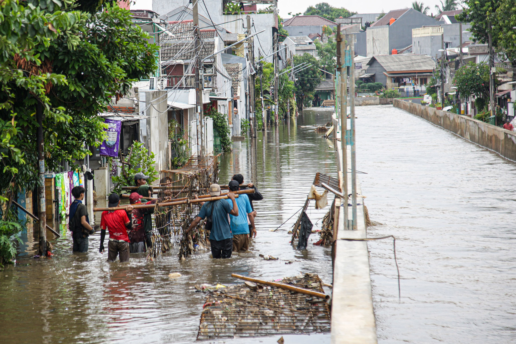 Sejumlah warga beraktifitas saat banjir menerjang Perumahan Taman Mangu Indah, Jurangmangu Barat, Pondok Aren, Tangerang Selatan, Selasa (12/11/2024).