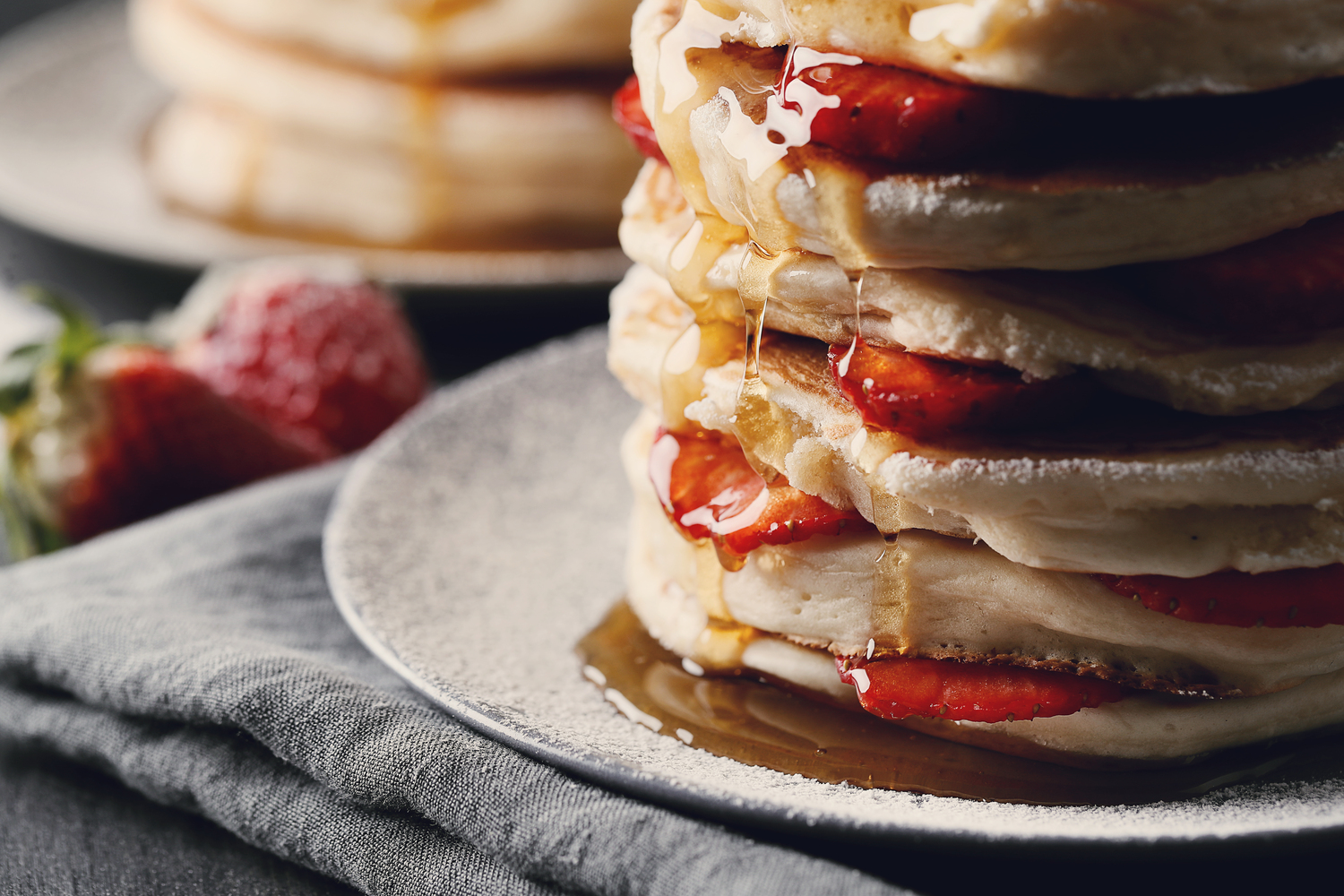 Ilustrasi pancake dengan topping sirop maple dan buah stroberi (Dok. Freepik/Racool_studio - Yeko Photo Studio)