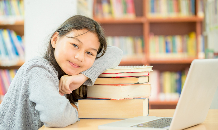 Ilustrasi anak perempuan belajar dengan laptop dan buku pelajaran.