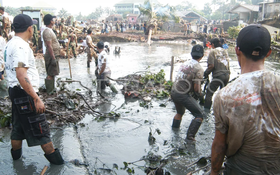Sejumlah relawan menggali lumpur untuk mencari korban di Situ Gintung, Tangerang pada 2009 silam
