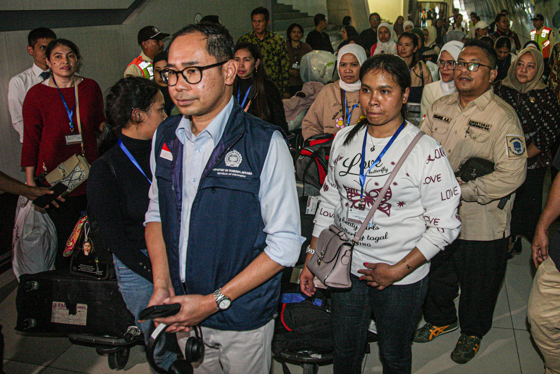 Direktur Perlindungan WNI Kemenlu Judha Nugraha (tengah) menerima Pekerja Migran Indonesia (PMI) dari Suriah menunjukan identitas dirinya saat tiba di Terminal 3, Bandara Soekarno-Hatta, Tangerang, Kamis (12/12/2024).