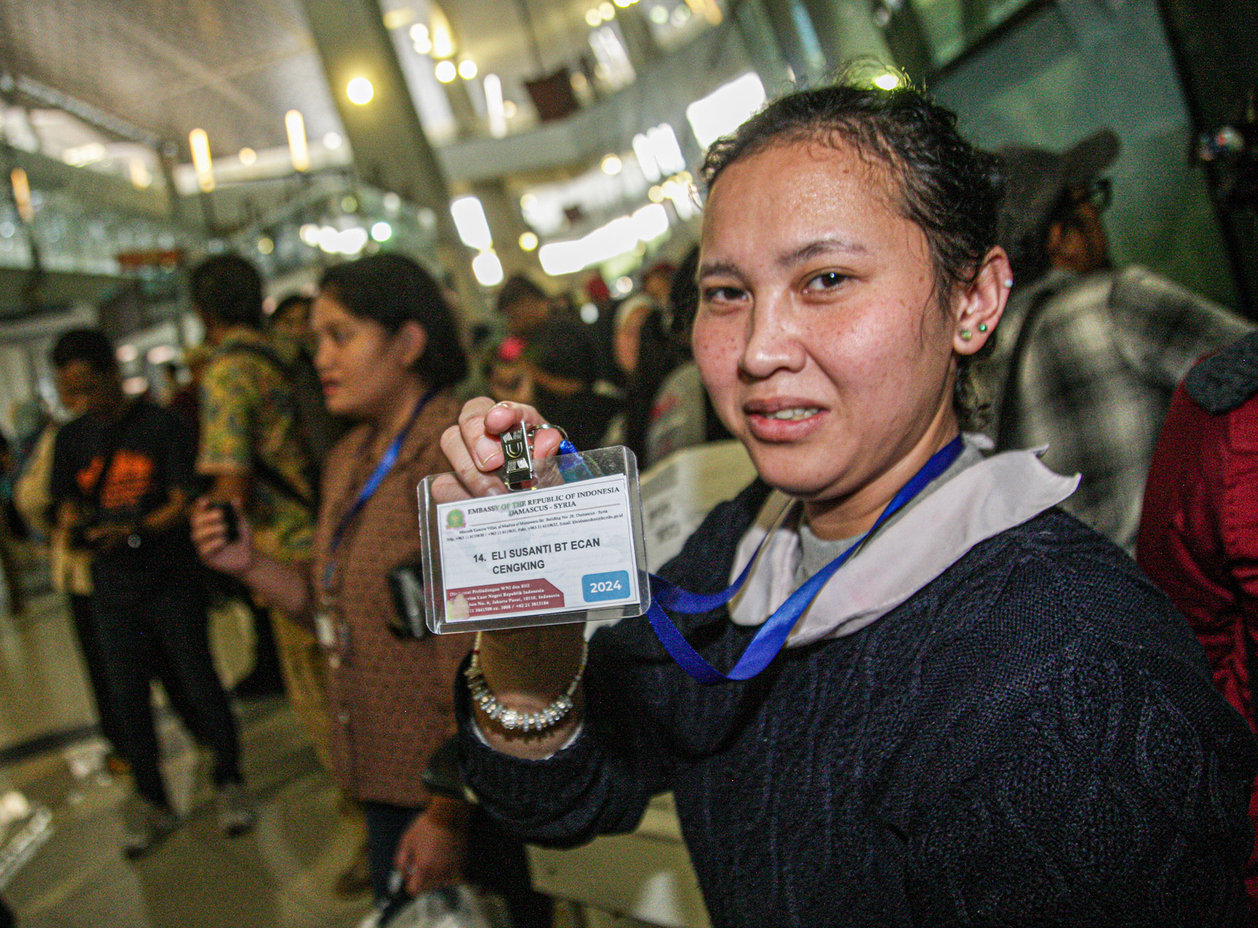 Seorang Pekerja Migran Indonesia (PMI) dari Suriah menunjukan identitas dirinya saat tiba di Terminal 3, Bandara Soekarno-Hatta, Tangerang, Kamis (12/12/2024).