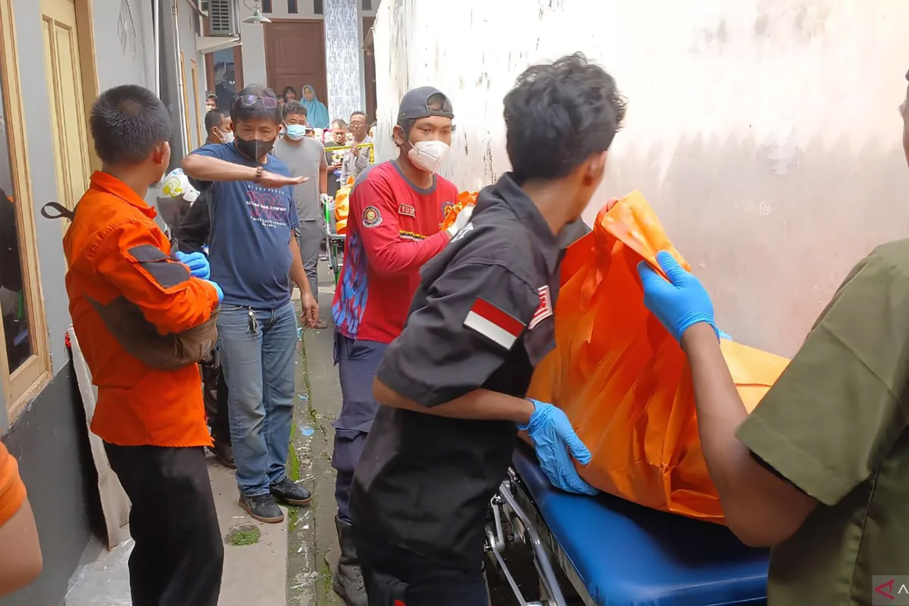 Petuga kepolisian mengevakuasi jenazah.