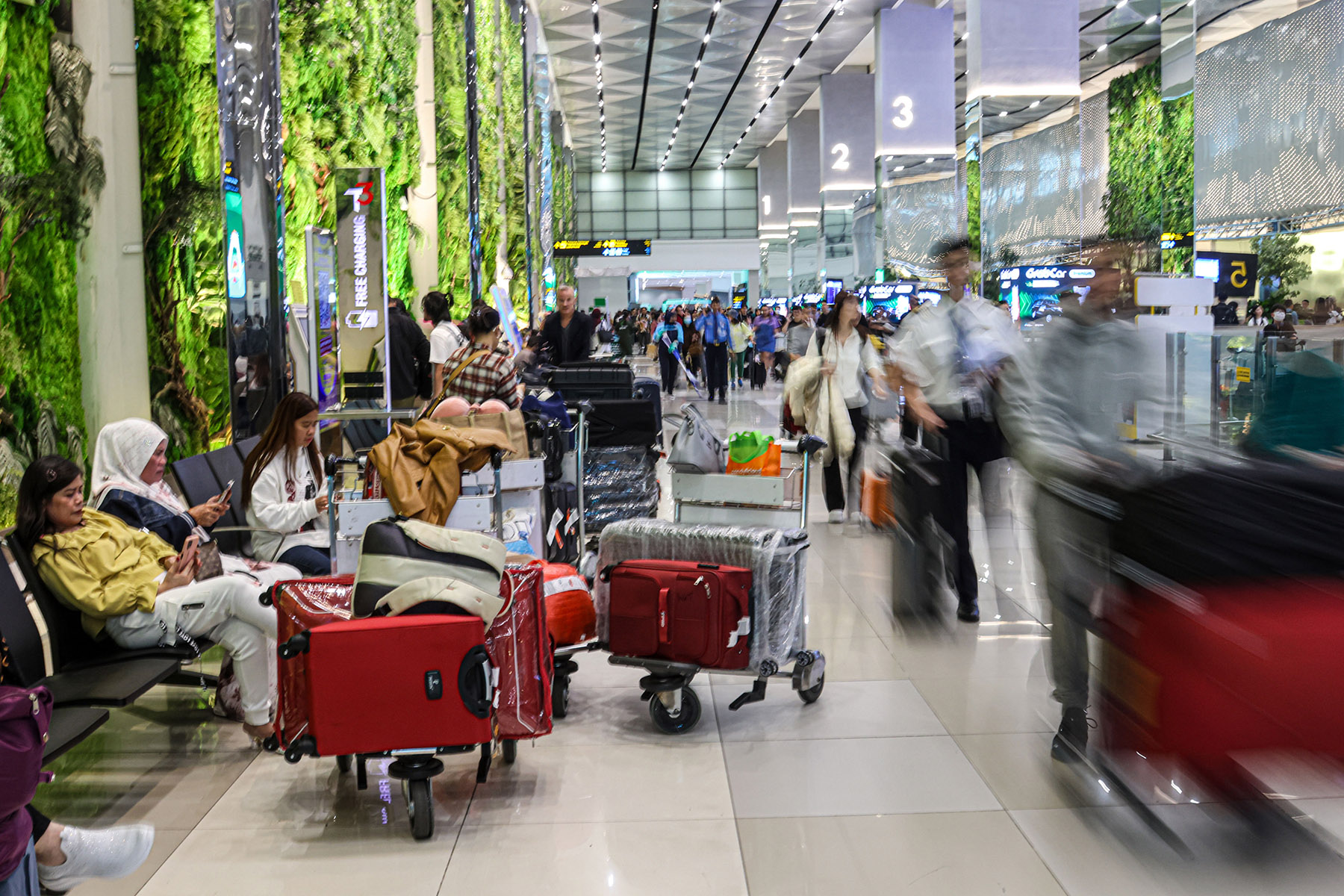 Sejumlah penumpang mengambil bagasi di Terminal 3, Bandara Soekarno-Hatta, Sabtu (21/12/2024).