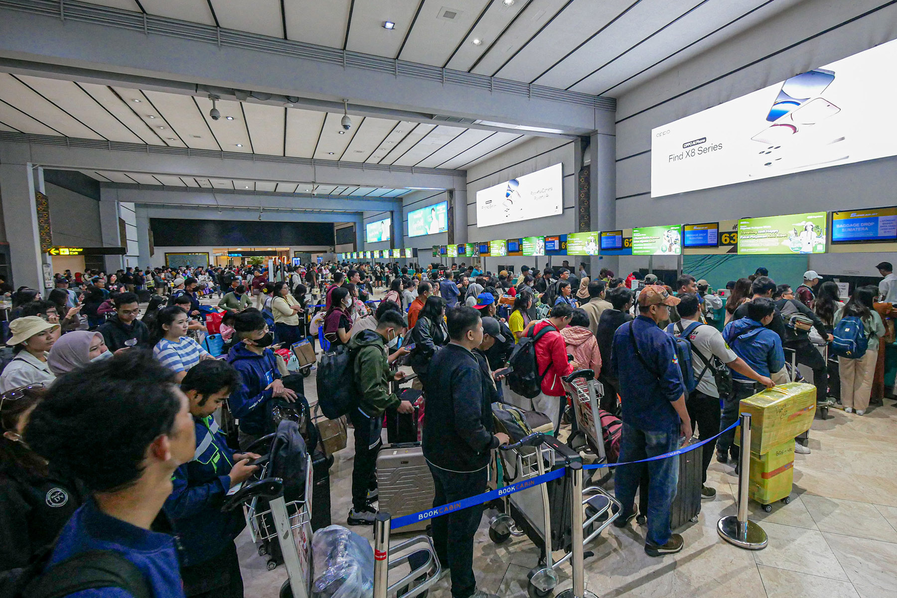 Sejumlah penumpang pesawat mengantri di counter check-in di Terminal 2, Bandara Soekarno-Hatta, Sabtu (21/12/2024).
