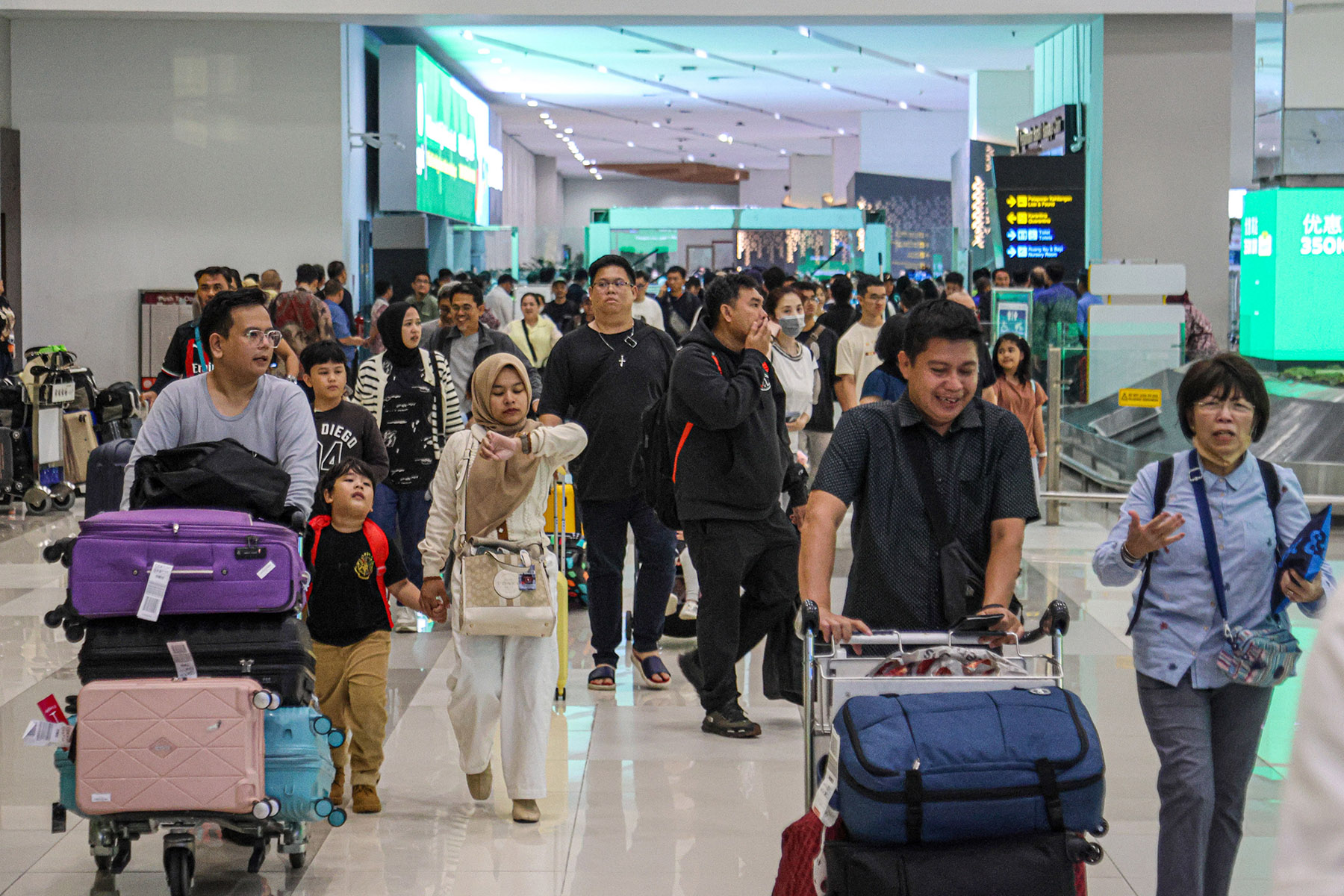 Sejumlah penumpang mengambil bagasi di Terminal 3, Bandara Soekarno-Hatta, Sabtu (21/12/2024).
