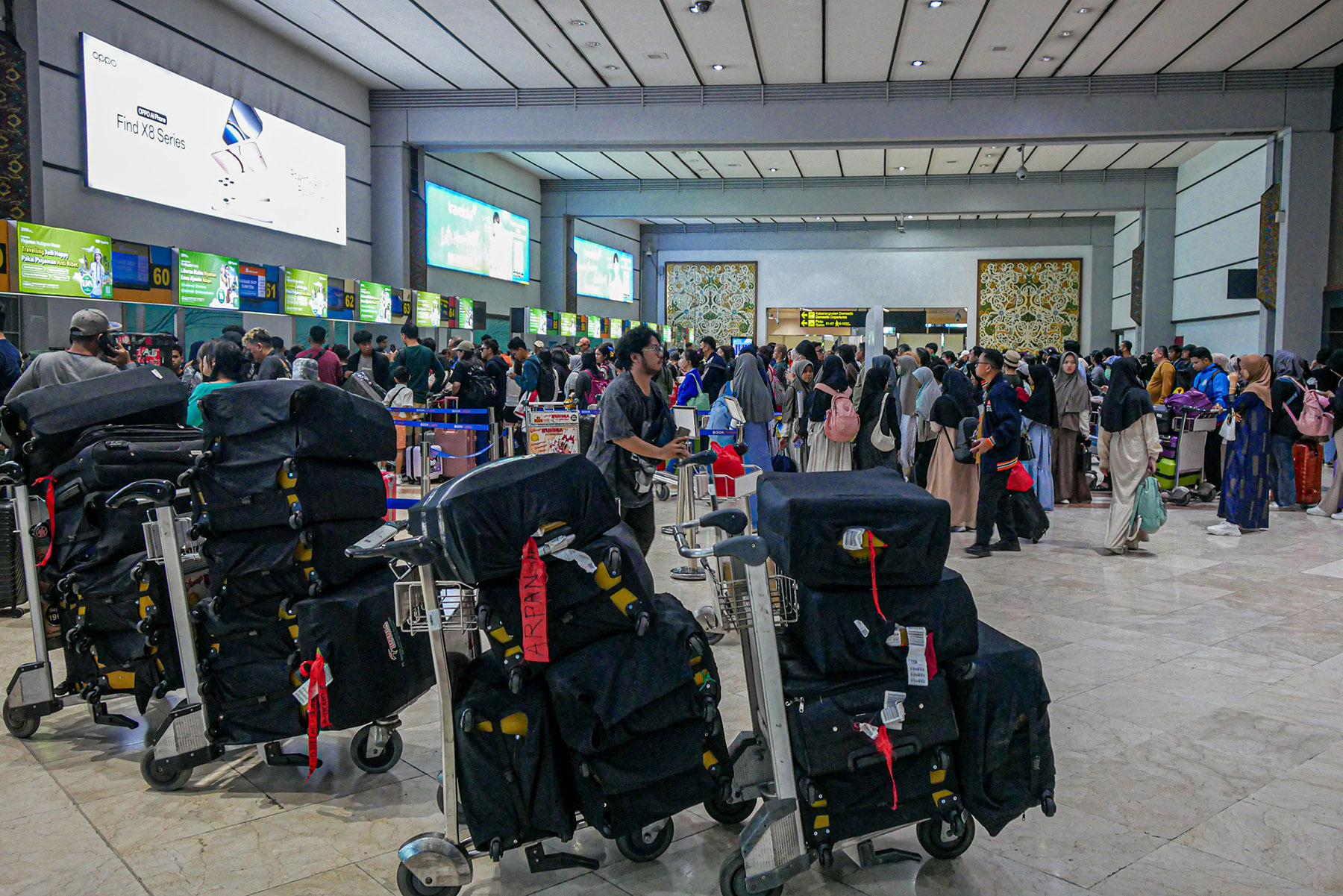 Sejumlah penumpang pesawat mengantri di counter check-in di Terminal 2, Bandara Soekarno-Hatta, Sabtu (21/12/2024).