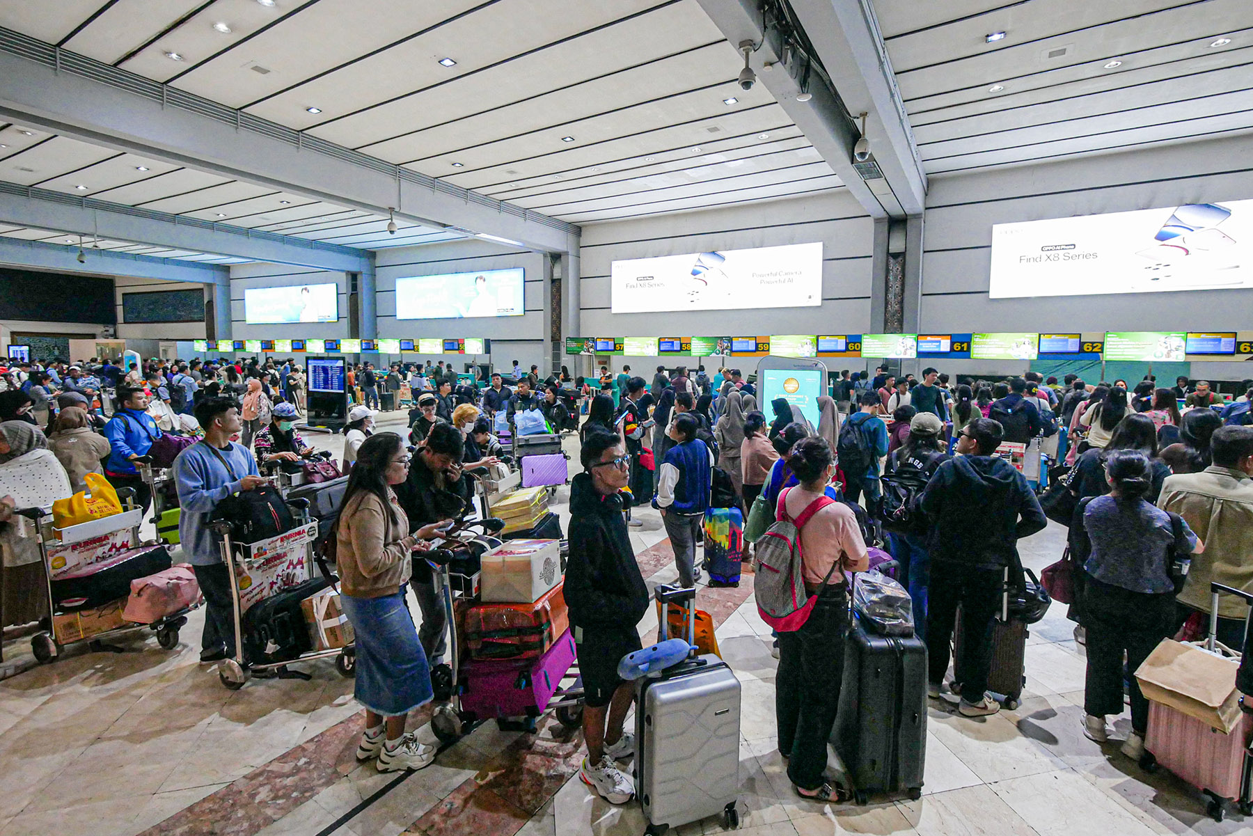 Sejumlah penumpang pesawat mengantri di counter check-in di Terminal 2, Bandara Soekarno-Hatta, Sabtu (21/12/2024).