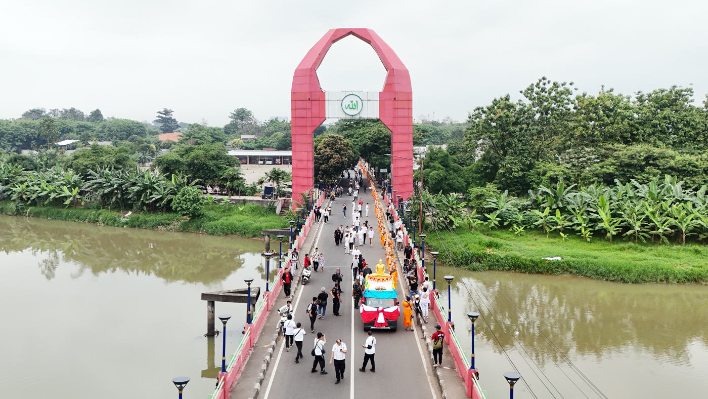 Foto udara Biksu Thudong bersama peserta Samanera berjalan melintasi Jembatan Merah dalam rangkaian Pabajja Samanera di Kota Tangerang, Banten, Minggu (29/12/2024).  (Dery Ridwansah/ JawaPos.com)
