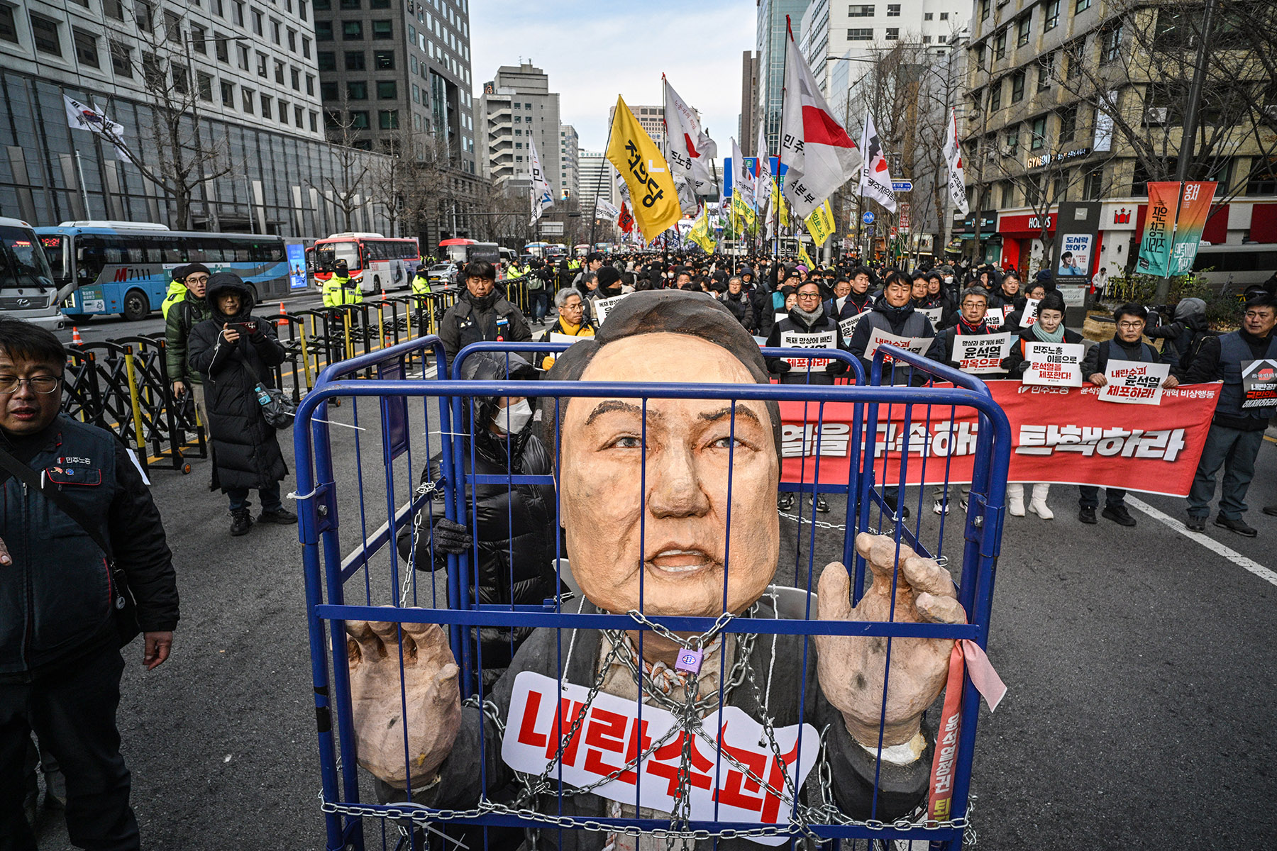 Demonstran membawa topeng besar Yoon Suk Yeol di Seoul.