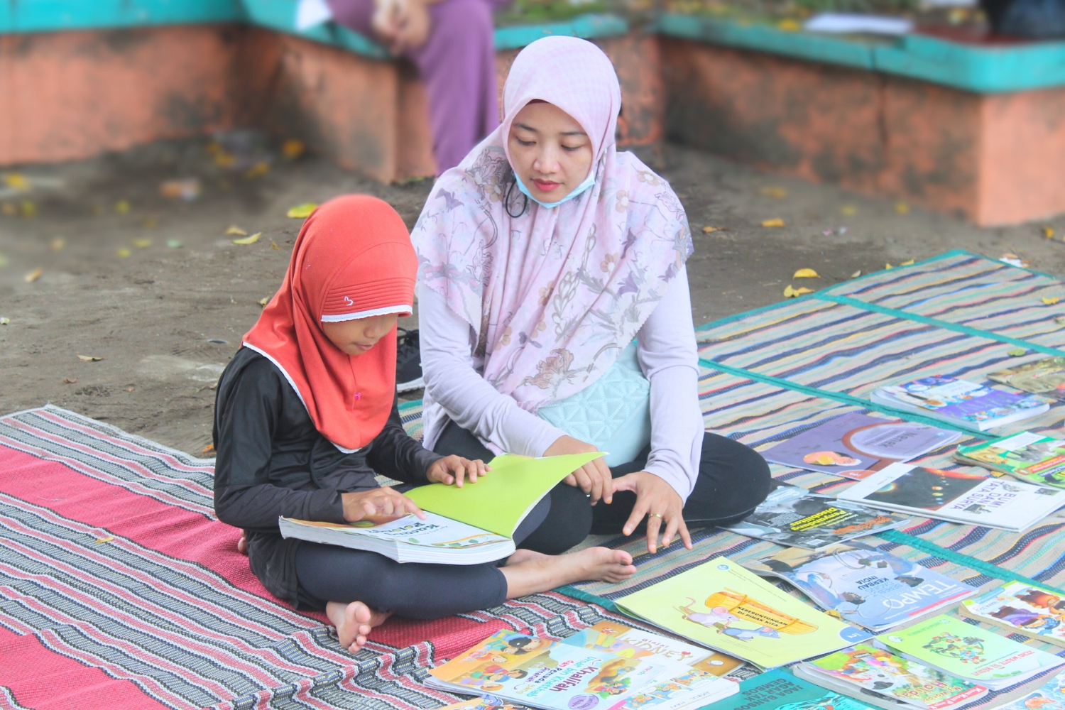 Ilustrasi seorang anak membaca buku sambil ditemani orang tua di taman bermain