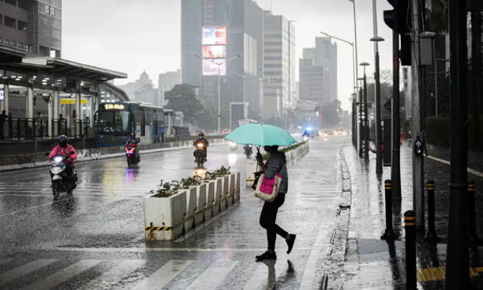 Warga melintasi jalan saat hujan di kawasan Jalan MH Thamrin, Jakarta, Senin (1/11/2021). (FOTO:MIFTAHULHAYAT/JAWA POS)
