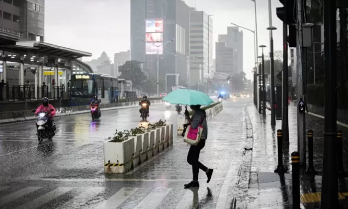 Warga melintasi jalan saat hujan di kawasan Jalan MH Thamrin, Jakarta, Senin (1/11/2021). (FOTO:MIFTAHULHAYAT/JAWA POS)