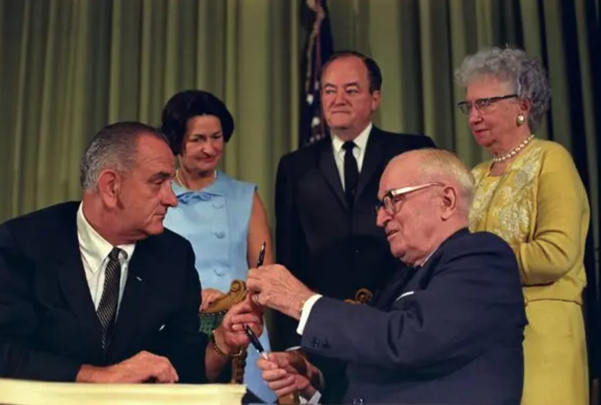 Presiden Johnson memberikan Medicare kepada Mantan Presiden Harry Truman dan Mantan Ibu Negara Bess Truman, 1965 (Dok. The New York Times)