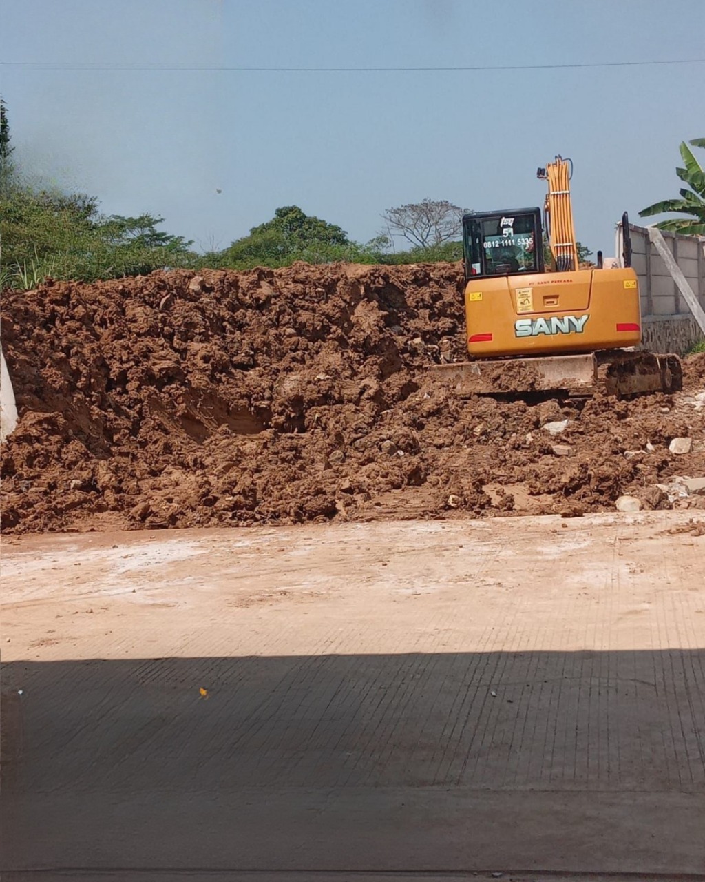 Proses penguatan turap oleh excavator.