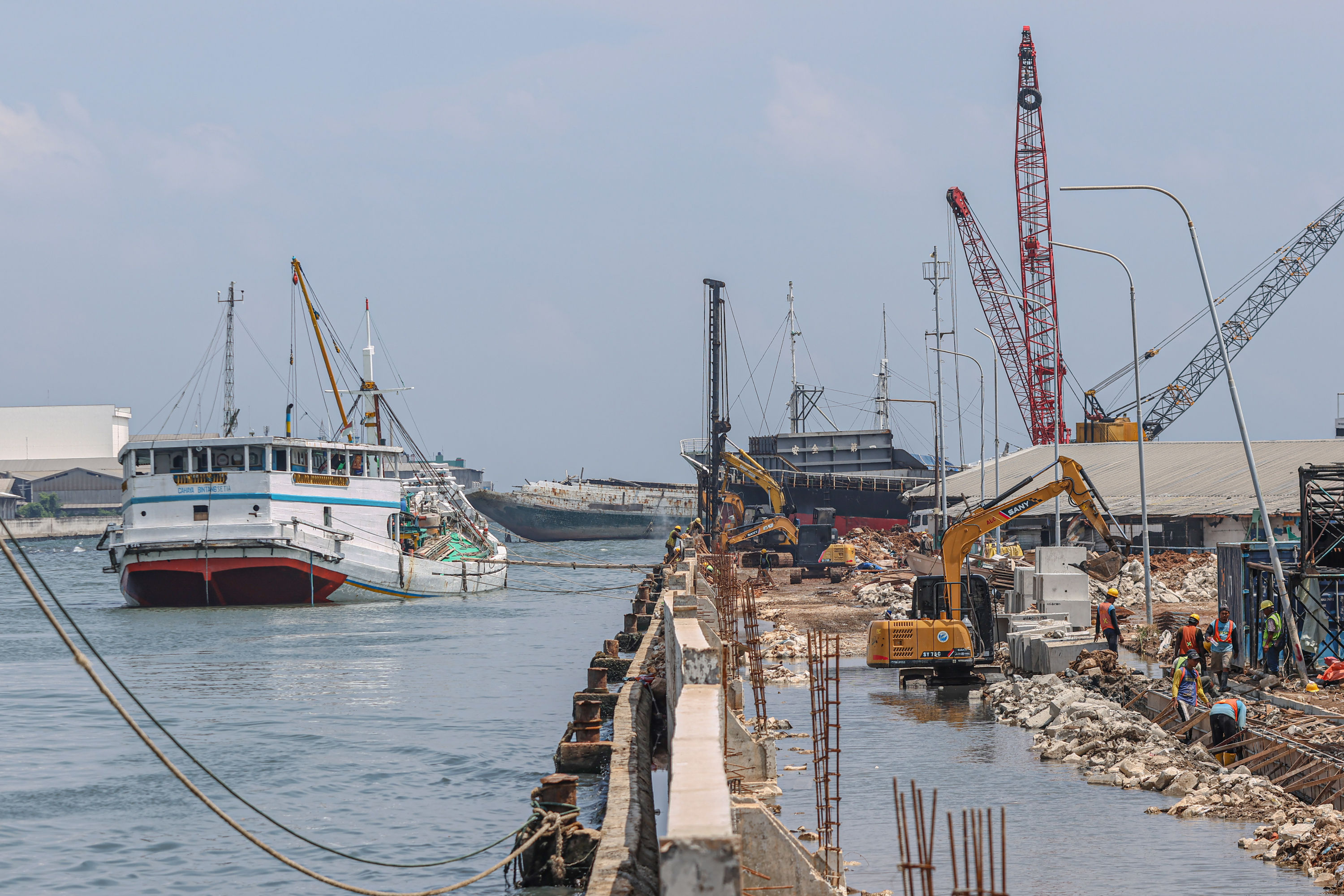 Pekerja menyelesaikan proyek pembangunan tanggul beton di Pelabuhan Sunda Kelapa, Jakarta, Selasa (14/10/2025). Tanggul sepanjang 1,2 kilometer ini ditargetkan rampung pertengahan November 2025 untuk mengantisipasi banjir rob. HANUNG HAMBARA/JAWA POS