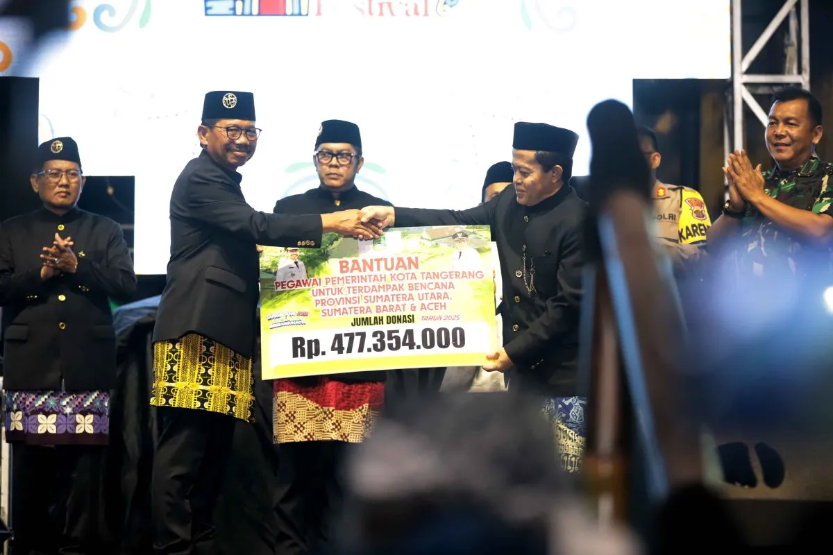 Wali Kota Tangerang Sachrudin (kiri) menyerahkan secara simbolis bantuan kepada Kepala Dinsos Mulyani (kanan) yang merupakan hasil urunan pegawai Pemkot Tangerang bagi korban bencana di Sumatera.