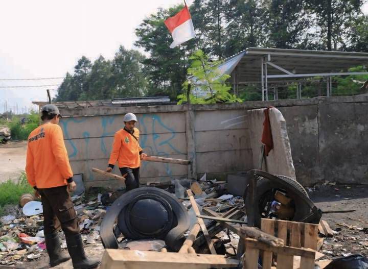 Petugas Kebersihan Dinas Lingkungan Hidup (DLH) Kota Tangerang melakukan pembersihan di area Tempat Pembuangan Sampah (TPS) Liar.