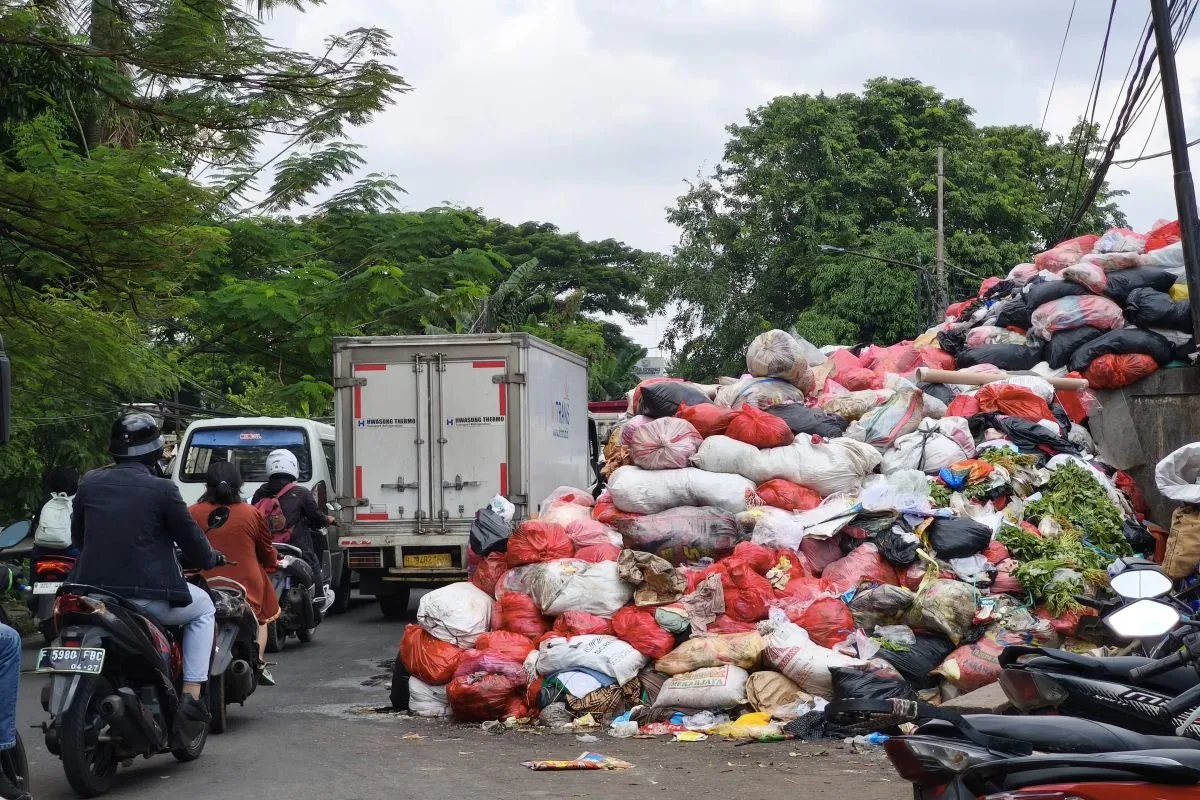 Sejumlah pengendara melintas di tupukan sampah yang ada di bahu Jalan Otista Raya, Ciputat, Tangerang Selatan (Tangsel), Banten. ANTARA/Azmi Samsul M