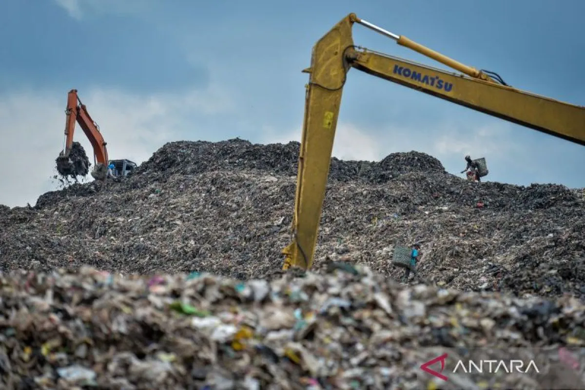 Pemulung memilah sampah di dekat ekskavator di Tempat Pembuangan Akhir (TPA) Cipeucang, Kota Tangerang Selatan, Banten, Jumat (26/12/2025).