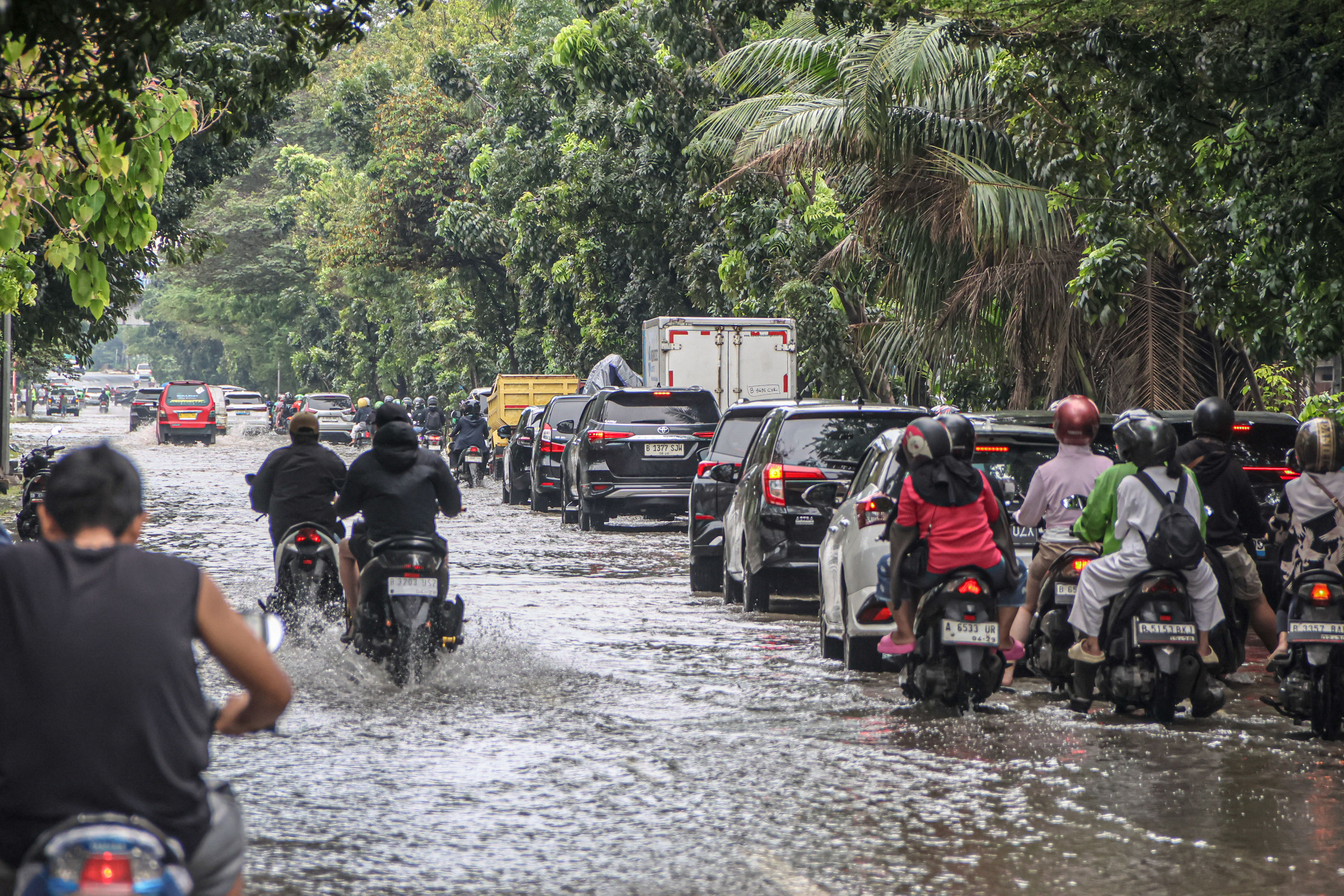 Sejumlah kendaraan melintasi genangan banjir di Jalan Tubagus Angke, Jakarta, Minggu (18/01/2026). Banjir kembali merendam sejumlah titik di wilayah Jakarta Timur, Jakarta Utara dan Jakarta Barat dikarenakan intensitas hujan tinggi yang turun sejak semala