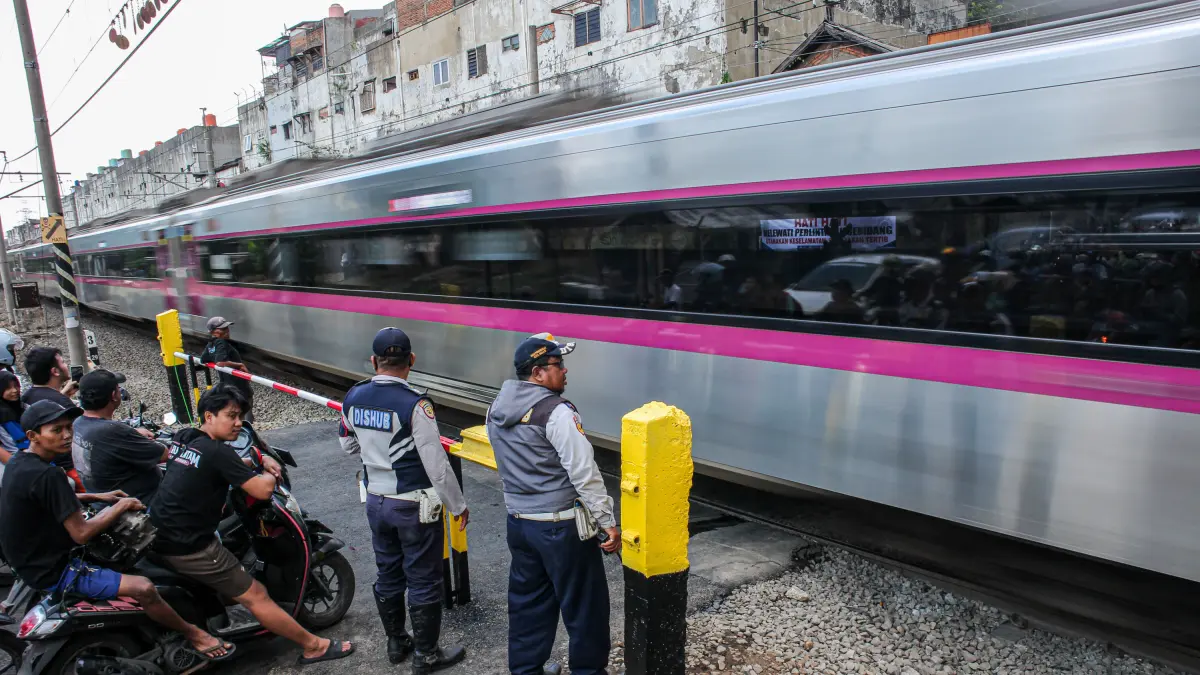 Suasana lalu lintas yang dijaga oleh petugas Dinas Perhubungan (Dishub) Kota Bekasi setelah pemasangan palang pintu di perlintasan sebidang di Jalan Ampera, Kota Bekasi, Sabtu (02/05/2026). PT Kereta Api Indonesia (KAI) melakukan pemasangan palang pintu di perlintasan sebidang Jalan Ampera, setelah terjadinya tabrakan kereta yang terjadi di Stasiun Bekasi Timur pada Senin (27/4). HANUNG HAMBARA/JAWA POS