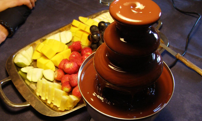 Ilustrasi dari chocolate fountain dengan buah-buahan.