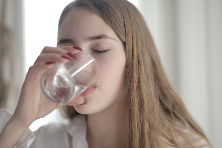 Ilustrasi seseorang yang sedang minum air mineral