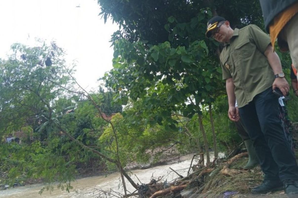 Pj Bupati Cirebon Wahyu Mijaya meninjau kondisi aliran Sungai Cipager di Kecamatan Sumber, Cirebon, Minggu (2/2). (Fathnur Rohman/Antara)