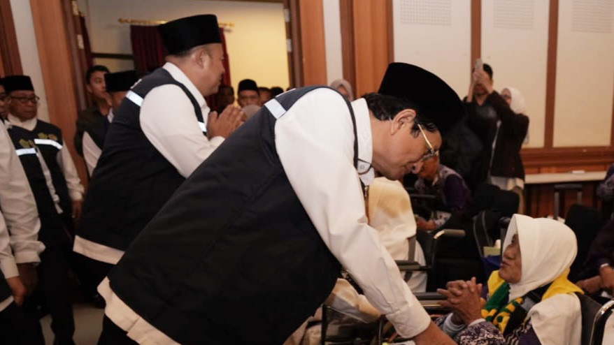 Menag Nasaruddin Umar berbincang hangat dengan salah satu jemaah kloter pertama JKG-01 di Asrama Haji Pondok Gede, Kamis (1/5/2025). (Dok. kemenag.go.id)