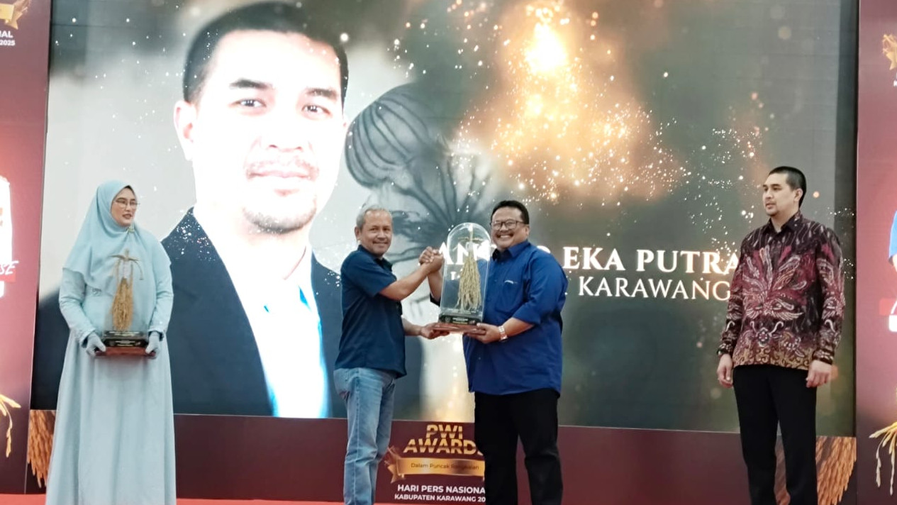 Kepala Kemenag Karawang, Sopian, menerima penghargaan Pramana Dharma dari Ketua PWI Karawang, Nila Kusuma, di Aula Husni Hamid (Dok. kemenag.go.id)