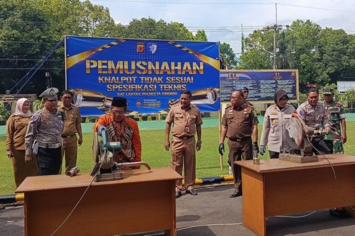 Petugas melakukan pemusnahan knalpot brong hasil razia di Mapolresta Cirebon, Senin (29/9). (Fathnur Rohman/Antara)