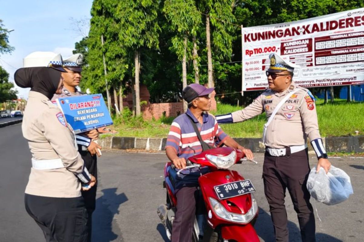 Petugas Satlantas Polres Kuningan bagikan helm gratis kepada para pengendara. (Fathnur Rohman/Antara)