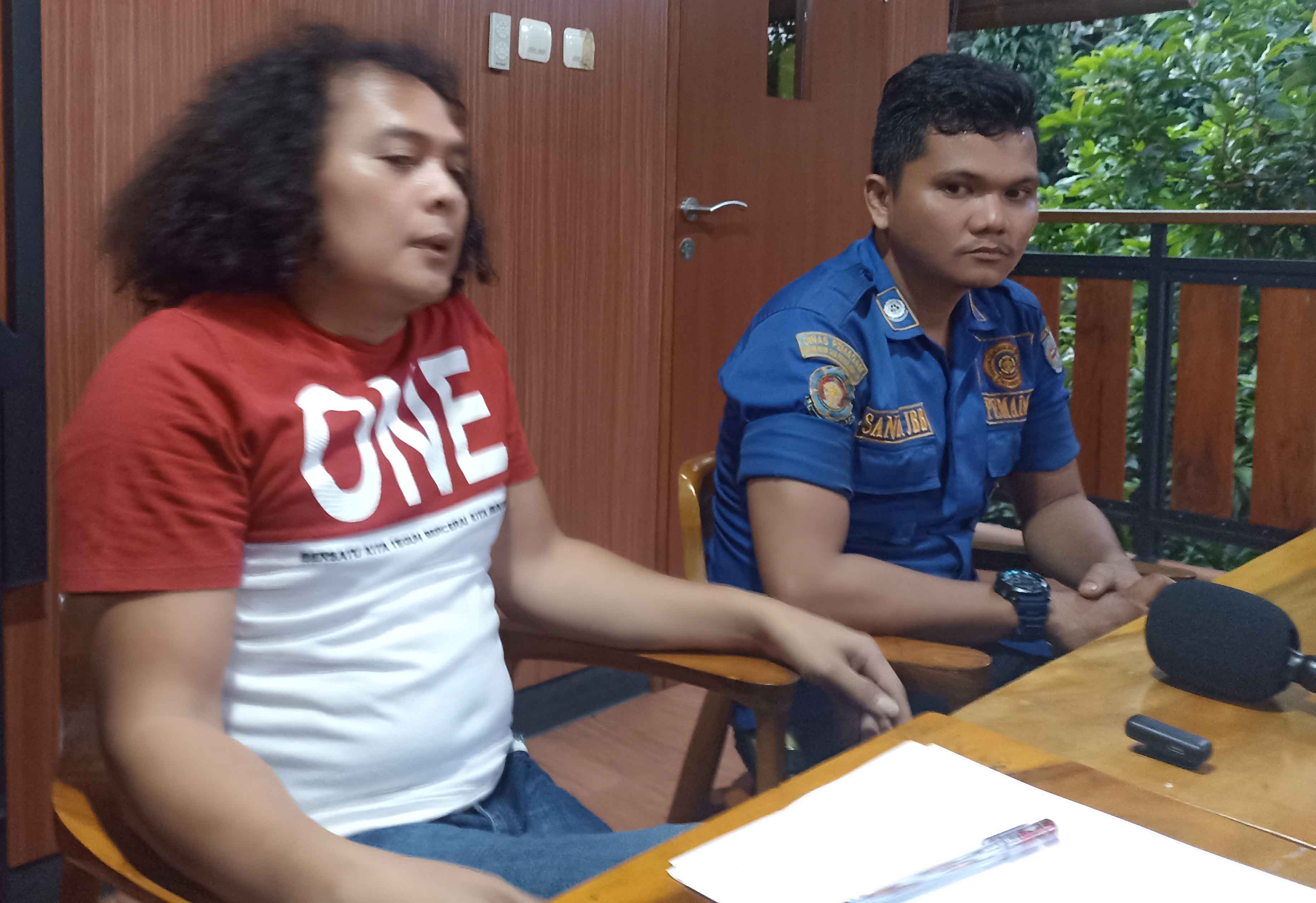 Pegawai Dinas Damkar Depok Sandi Butar Butar (kanan) bertemu dengan kuasa hukum Deolipa di kawasan Sukmajaya. (Febry Ferdian/Jawa Pos)