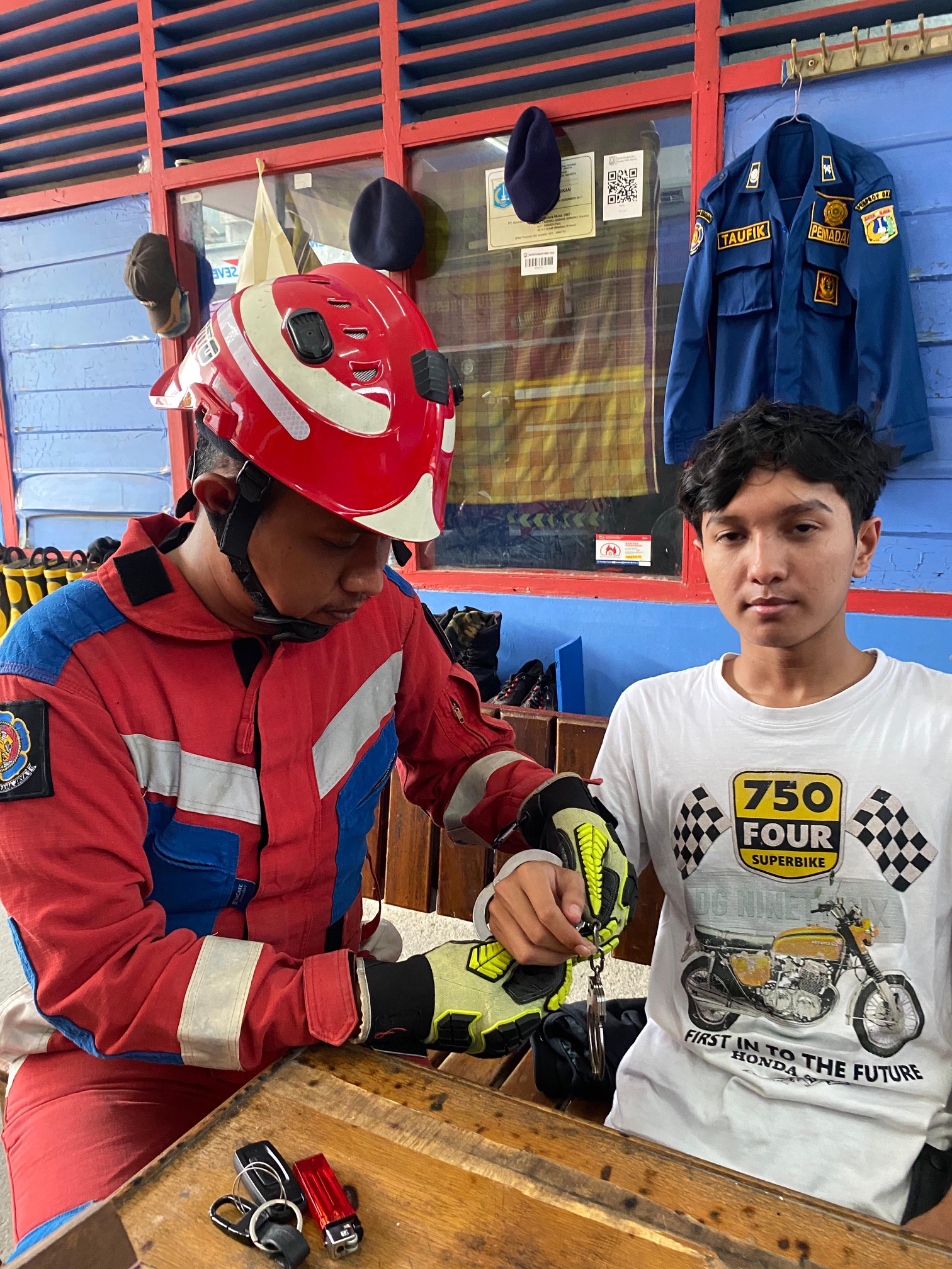 Petugas Pos Damkar Pulomas membantu warga yang diborgol.