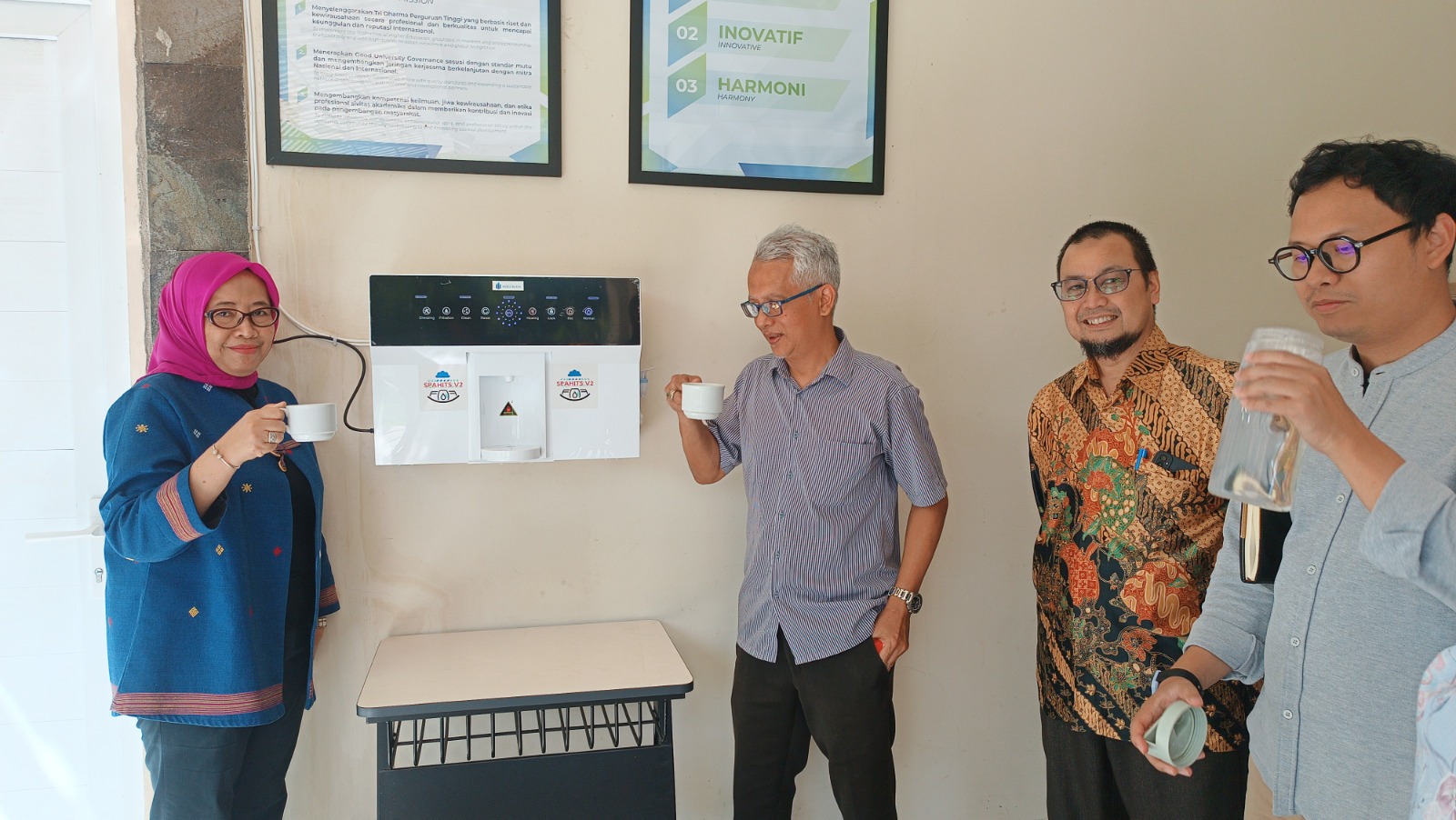 Peneliti dari UMB mencoba minum air mineral yang diproduksi dari dispenser SPAHITS.