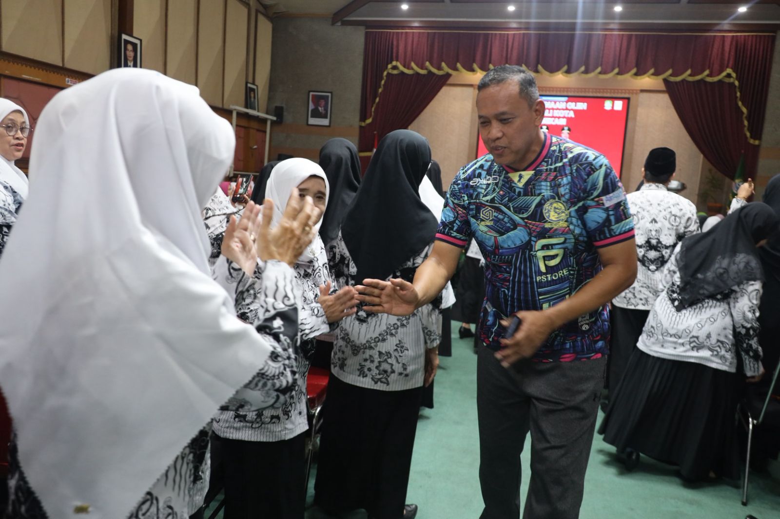 Wali Kota Bekasi Tri Adhianto bersalaman dengan para guru setelah membuka kegiatan peningkatan kualitas guru yang digelar Dinas Pendidikan Kota Bekasi di Balai Patriot.
