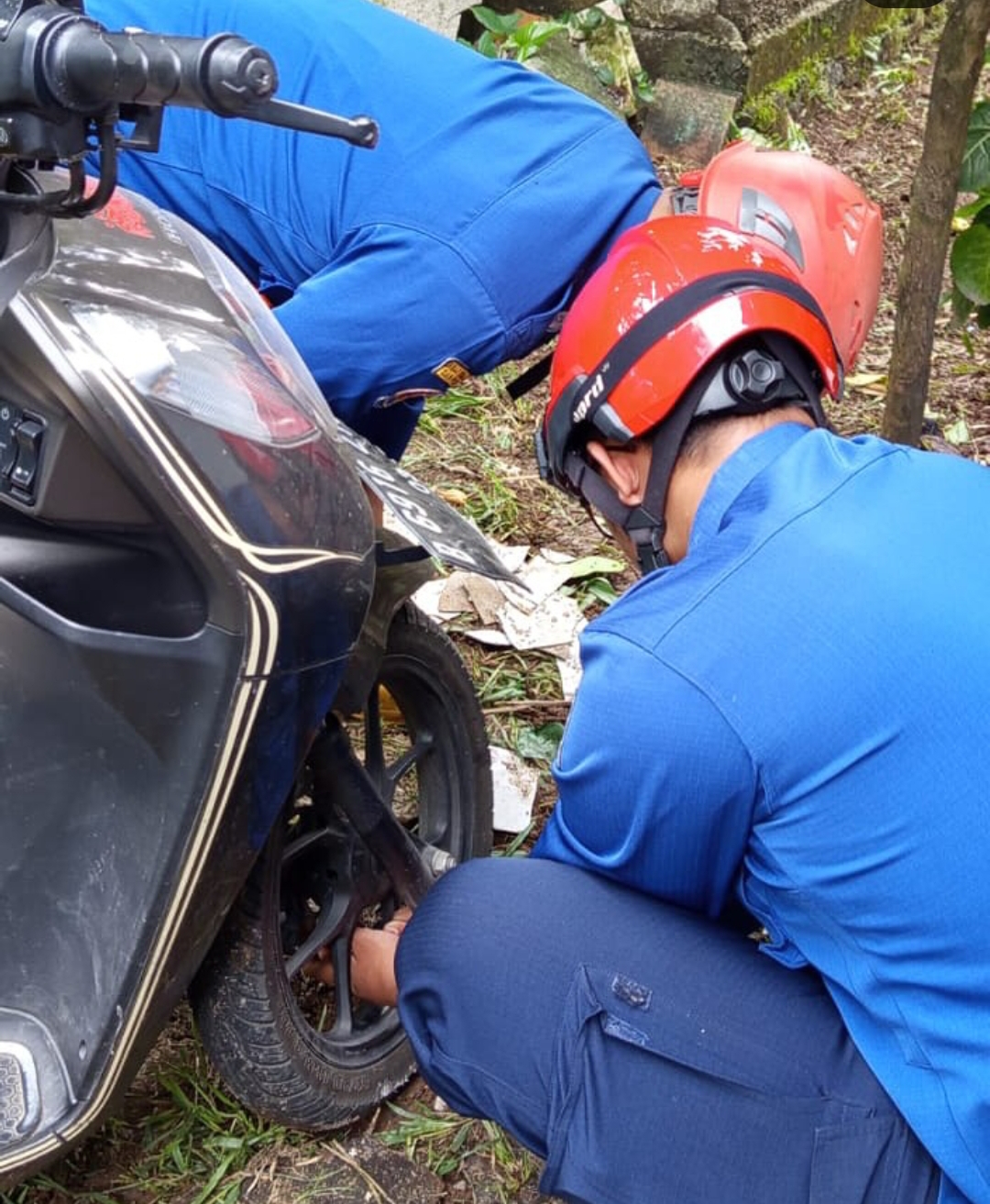 Petugas Damkar Depok memperbaiki kunci ganda motor milik warga di Cipayung.