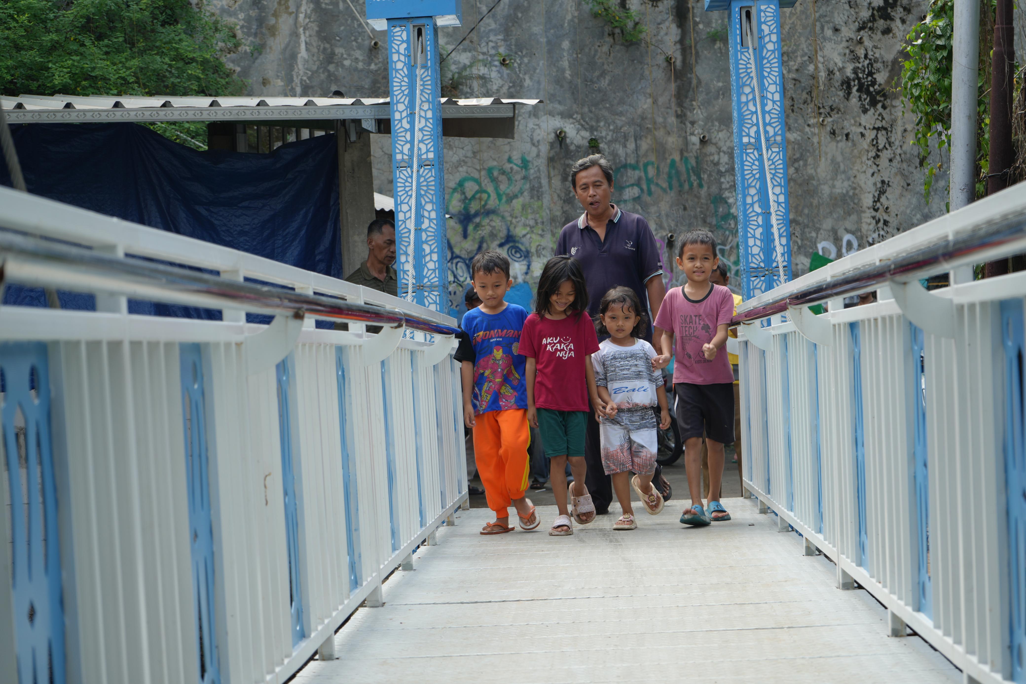 Anak-anak mencoba menyeberang menggunakan jembatan angkat di kawasan Gandaria, Jakarta Selatan.