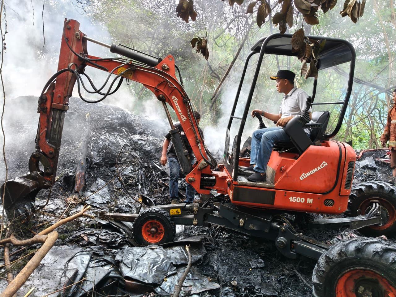 Petugas berusaha mendinginkan api di lahan kosong bekas penimbunan limbah karet di Jalan Prabu Siliwangi, Kecamatan Periuk, Kota Tangerang.