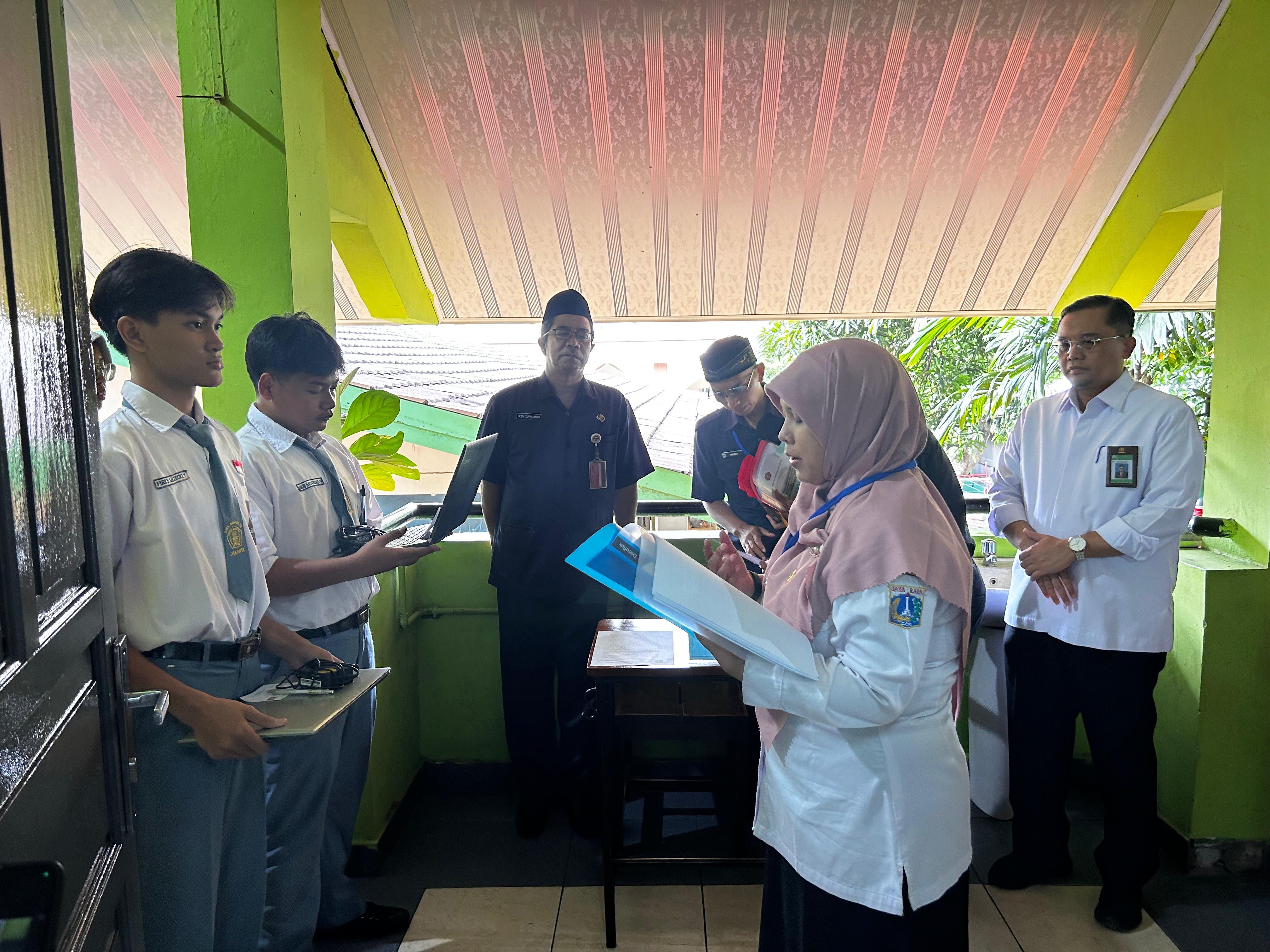 Para murid kelas XII SMAN 78 Jakarta diabsen oleh pengawas sebelum memasuki ruangan tes pada Senin (3/11).