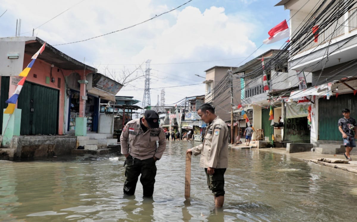 Petugas kepolisian terjebak di arena kawasan banjir rob, Tanjung Priok, Jakarta utara.