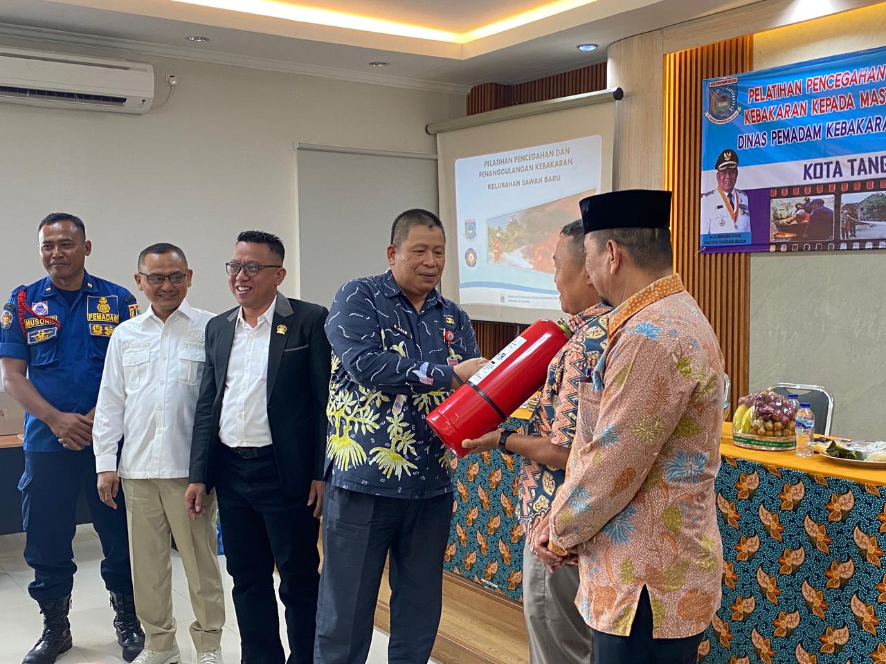Kepala Dinas Damkar dan Penyelamatan Kota Tangsel Ahmad Dohiri memberikan alat pemadam kebakaran kepada masyarakat di Kelurahan Sawah Baru, Kecamatan Ciputat, Kamis (13/11).