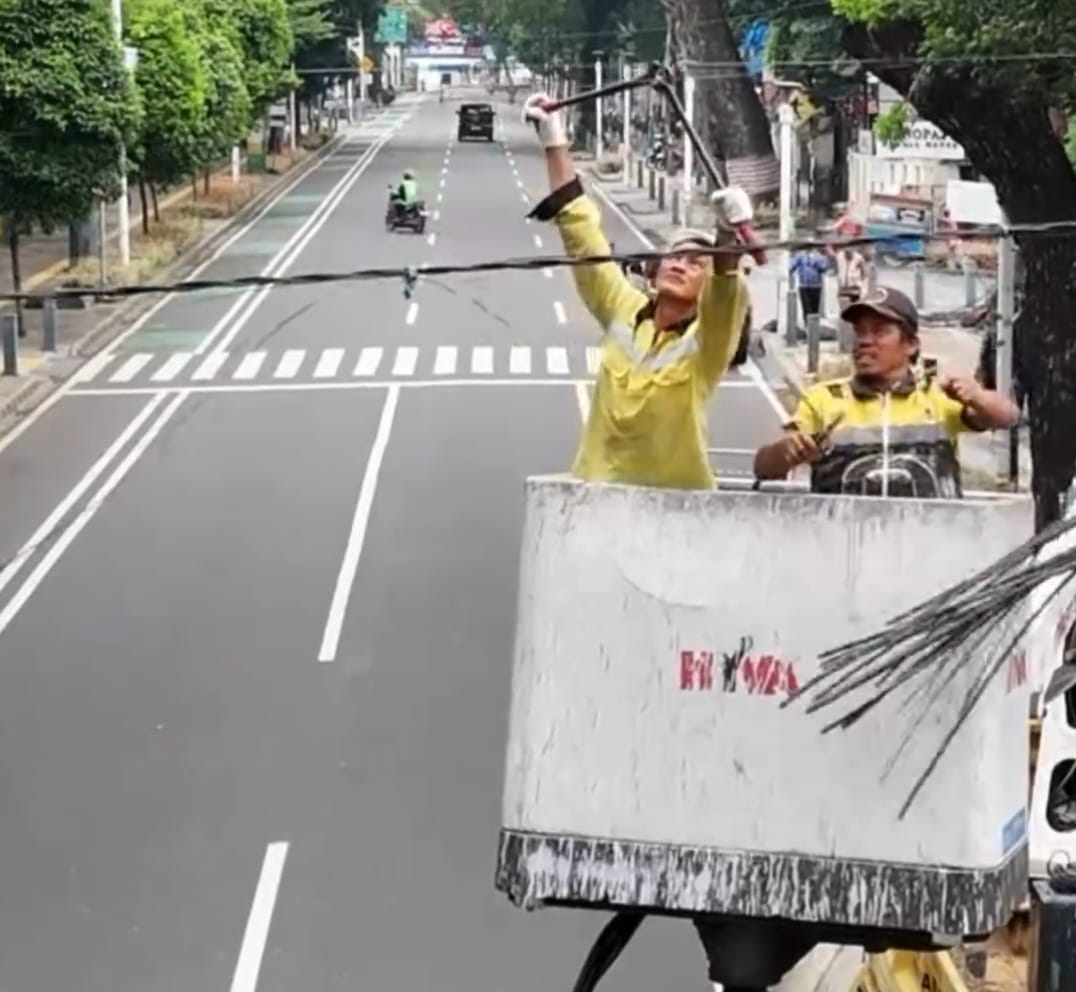 Petugas Dishub Kuningan merapikan kabel yang menjuntai hingga mengganggu ketertiban umum.
