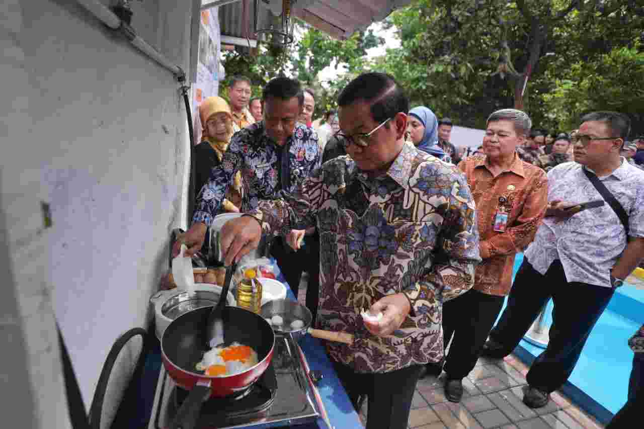 Gubernur DKI Pramono Anung memasak di sela-sela kegiatan Instalasi Biodigester Komunal di Kelurahan Pekayon, Pasar Rebo, Jakarta Timur.