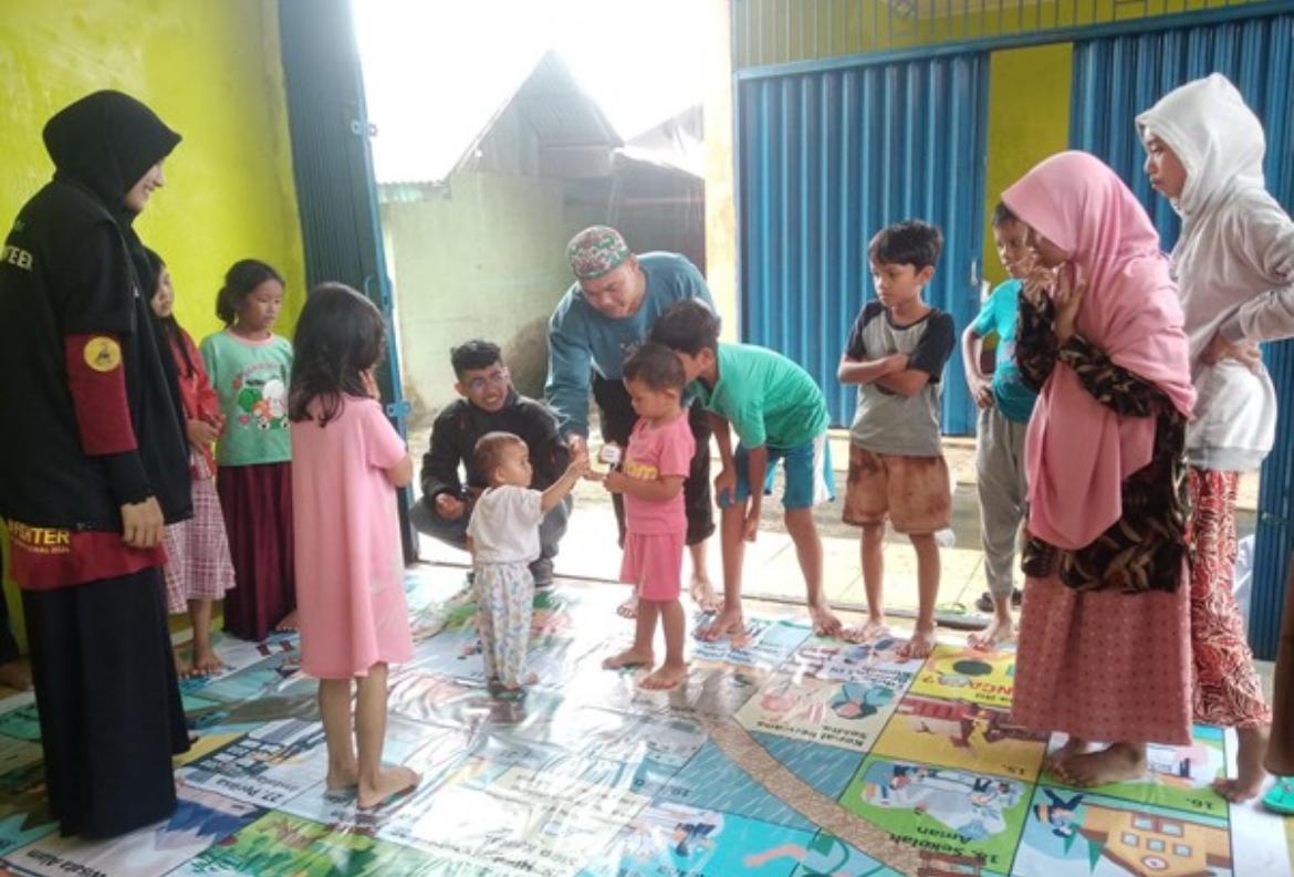 TAMAN CERIA: Anak-anak korban banjir bandang bermain ular tangga kebencanaan di kampung Galapuang, Padang Pariaman, Sumatera Barat.