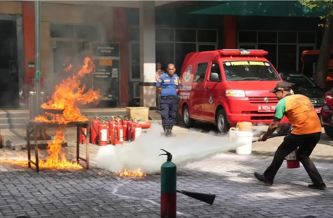 Petugas Gulkarmat Jakarta Timur memperagakan cara memadamkan api dengan tepat.