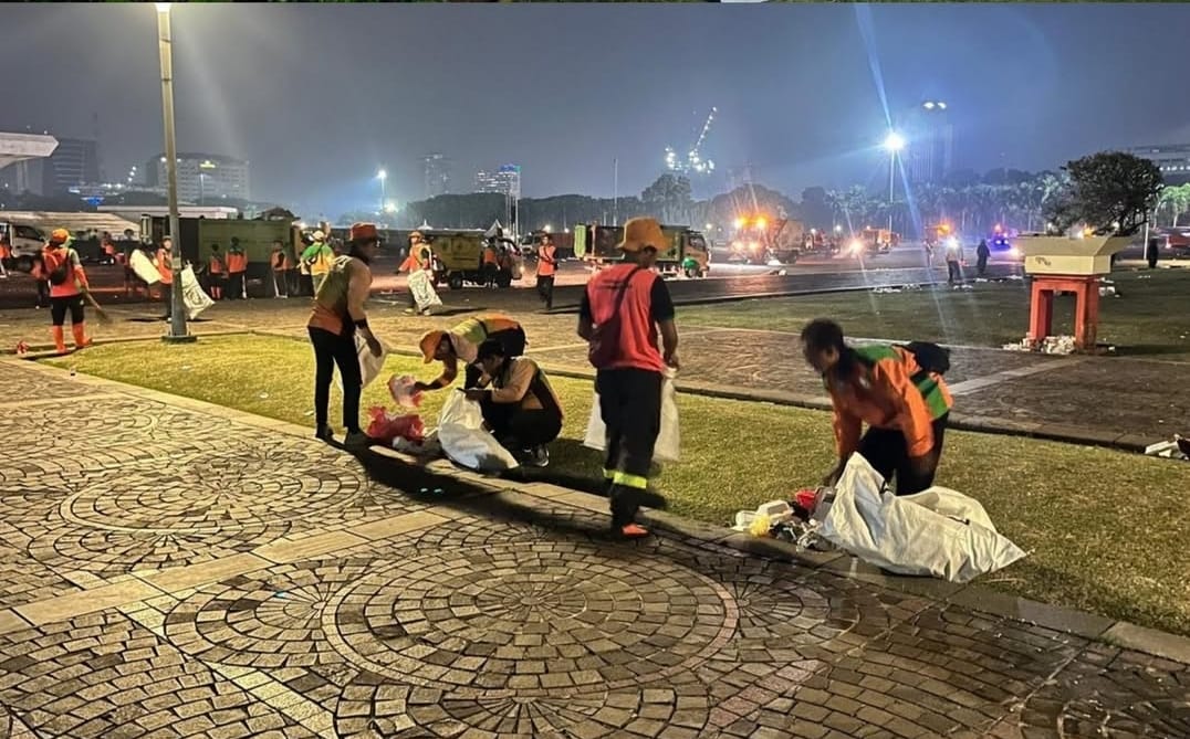 Petugas LH DKI Jakarta membersihkan sampah pasca acara di Monas, Jakarta Pusat.